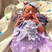 Elana joined the competition — help win amazing prizes! newborn, baby, infant, portrait, hospital, hospital_bed, blanket, lavender_dress, headband, bow, floral_dress, baby_girl, face, hands, smiling, awake, birth_card, bedding, indoor, photography