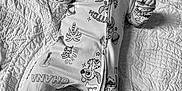 Lakota is registered to the contest to win money with this photo: baby, bed, black_and_white, blanket, cartoon_character, curious, cute, face, feet, hand, infant, lying_down, monochrome, onesie, pacifier, pattern, portrait, quilt, sleepwear, textured_bedding