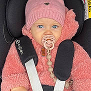 Lou participe au concours pour gagner de l'argent avec cette photo : baby, child, car_seat, pink_hat, pom_pom, pacifier, blue_eyes, fluffy_jacket, safety_harness, cute, infant, winter_clothing, warm, seatbelt, portrait, young_child, indoors, close_up, person, child_safety