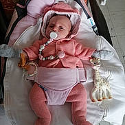 Malya participe au concours pour gagner de l'argent avec cette photo : baby, baby_carrier, blanket, child, comfort, cozy, cute, floor, giraffe_toy, indoor, infant, knitted_outfit, mittens, pacifier, person, pink_clothing, portrait, resting, small, toy