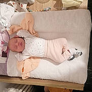 Malya a rejoint le concours — aidez-le/la à gagner de superbes lots ! baby, newborn, sleeping, infant, changing_pad, blanket, clothing, sock, wooden_furniture, baby_girl, baby_boy, pastel_colors, soft_texture, cute, peaceful, indoors, baby_accessories, nursery, baby_care, resting