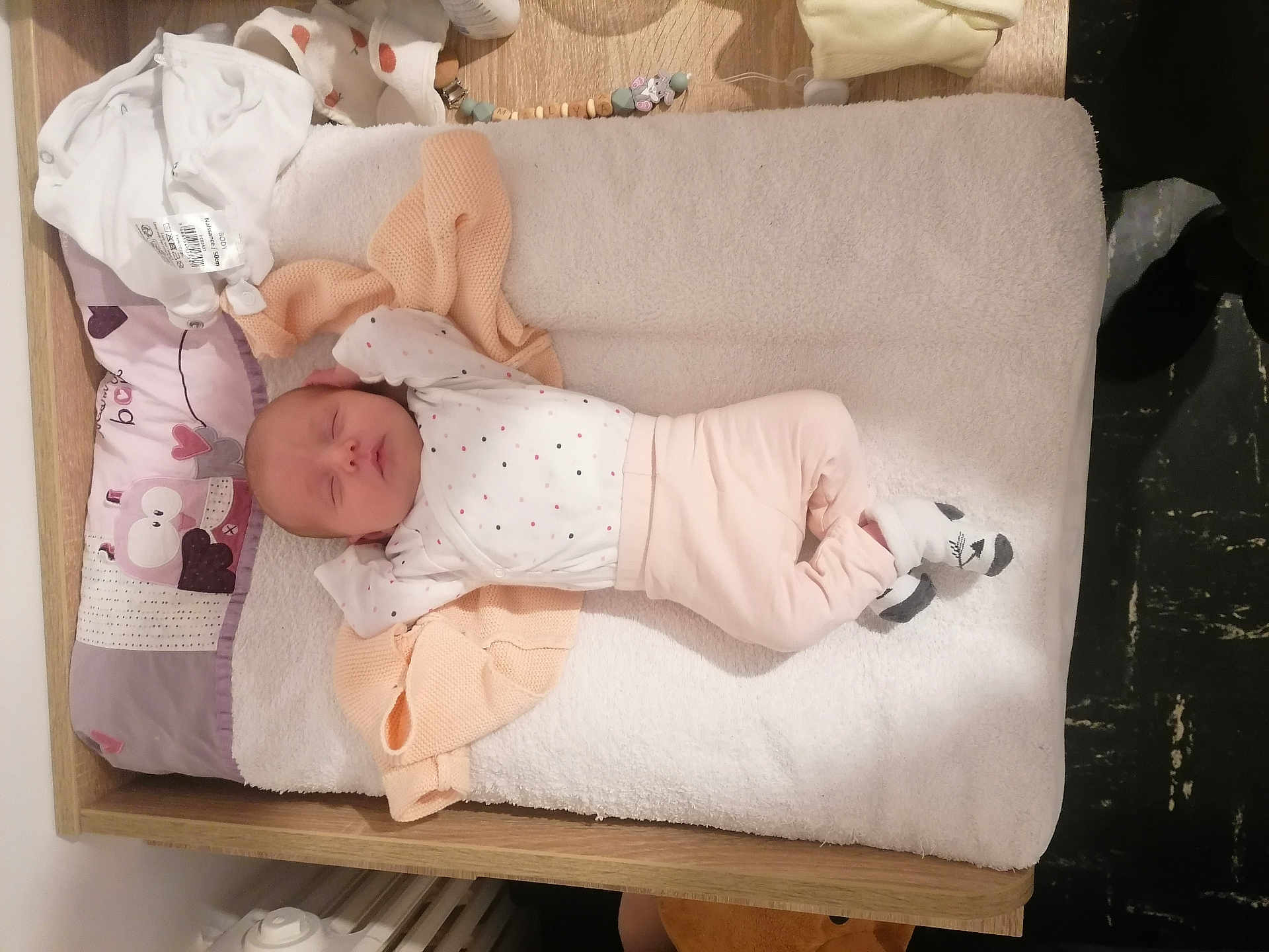 Malya a rejoint le concours — aidez-le/la à gagner de superbes lots ! baby, newborn, sleeping, infant, changing_pad, blanket, clothing, sock, wooden_furniture, baby_girl, baby_boy, pastel_colors, soft_texture, cute, peaceful, indoors, baby_accessories, nursery, baby_care, resting