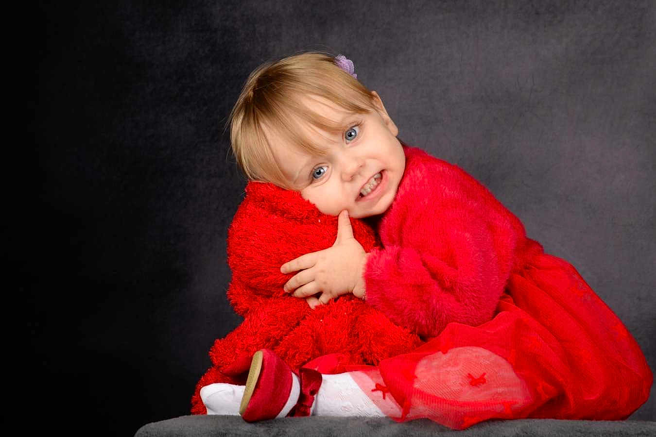 Katalyna participe au concours pour gagner de l'argent avec cette photo : toddler, child, red_clothing, smile, hugging, plush, portrait, studio, cute, happy, girl, dress, sitting, soft_texture, indoor, blond_hair, blue_eyes, cozy, fashion, innocence