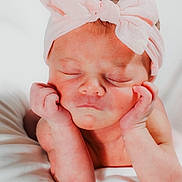 Luna is registered to the contest to win money with this photo: newborn, baby, infant, headband, pink_bow, sleeping, hands, face, skin, cute, portrait, resting, white_blanket, peaceful, child, closeup, adorable, soft_light, infancy, young_child