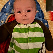 Joseph joined the competition — help win amazing prizes! baby, infant, face, eyes, blanket, striped_clothing, monkey_patch, green, white, brown, soft_texture, lying_down, cute, child, portrait, indoors, warm_colors, expression, young, cozy