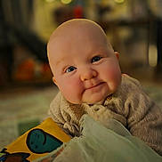 Marnie joined the competition — help win amazing prizes! baby, infant, child, face, smile, cheeks, sweater, blanket, toy, indoors, portrait, cute, warm_lighting, soft_focus, cozy, curious, expression, head, skin, happy