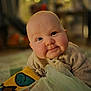baby, infant, child, face, smile, cheeks, sweater, blanket, toy, indoors, portrait, cute, warm_lighting, soft_focus, cozy, curious, expression, head, skin, happy