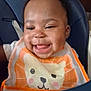 baby, child, smiling, high_chair, bib, indoor, face, happy, cute, infant, person, clothing, seat, portrait, wooden_wall, cheerful, young_child, babysitting, feeding_time, domestic