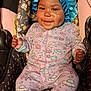 baby, child, smile, car_seat, onesie, bonnet, happy, infant, clothing, pattern, space_theme, rocket, ufo, rainbow, planet, seat, fabric, cute, portrait, indoors