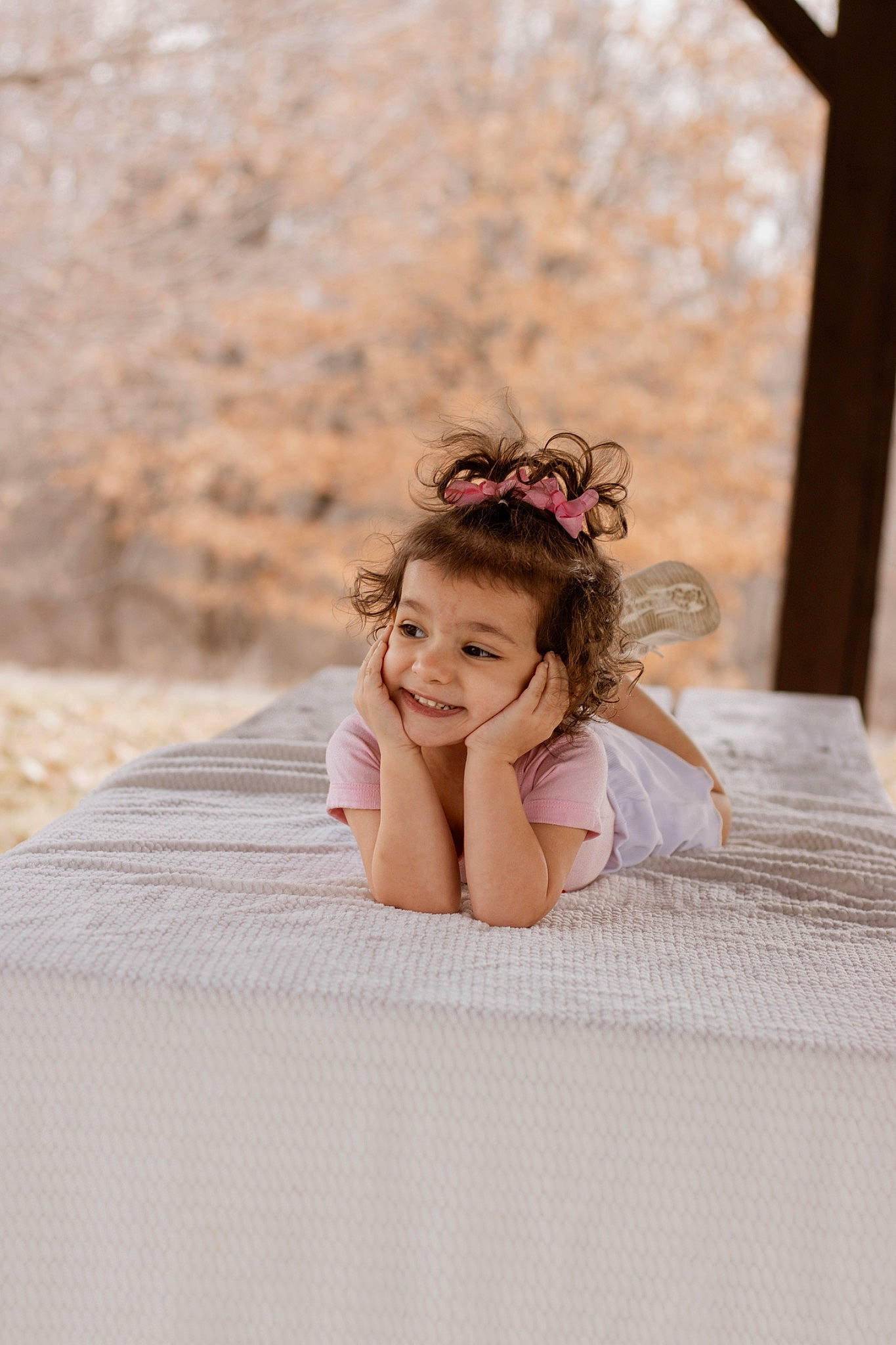 Nilah is registered to the contest to win money with this photo: bed, bridal_clothing, brown_hair, child, dress, event, flash_photography, flooring, fun, grass, hair, happy, headpiece, joy, leisure, linens, person, sitting, skin, smile
