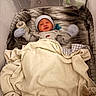 baby, baby_bottle, bassinet, blanket, caregiver_gear, cozy, cream, crying, gray, hat, indoor, infant, mittens, newborn, nursery, pacifier, portrait, sleeping, swaddle, textile