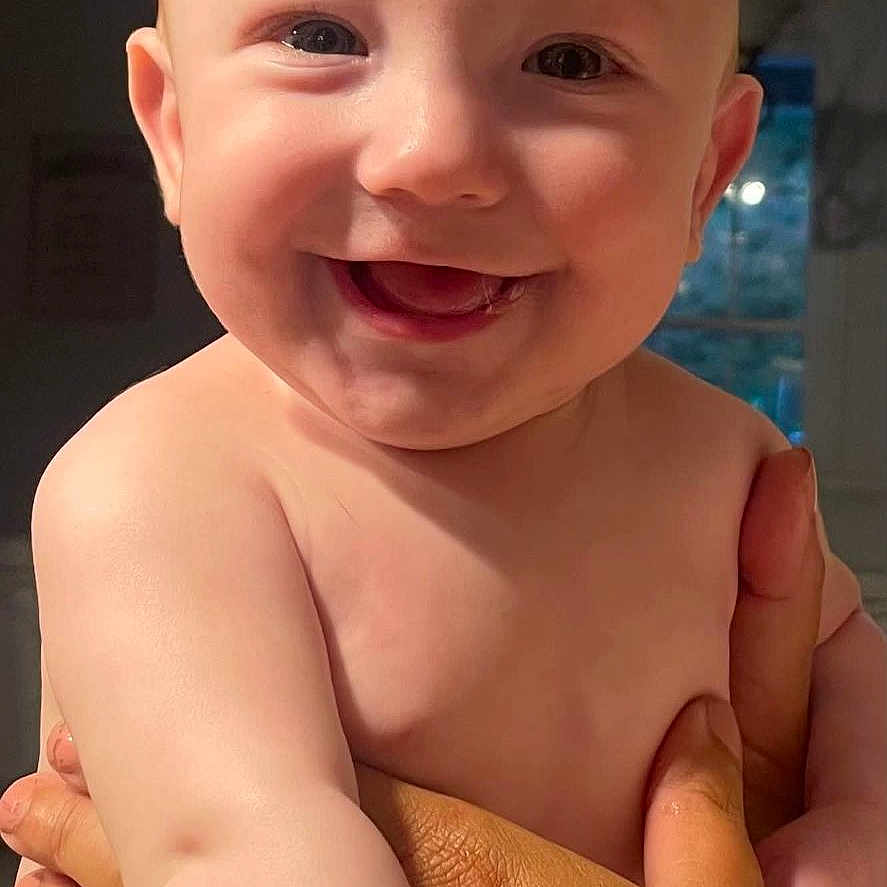 Ryland is registered to the contest to win money with this photo: adult_hands, baby, child, closeup, cute, diaper, expression, face, hands, happy, holding, human, indoor, infant, light, person, portrait, rings, skin, smiling