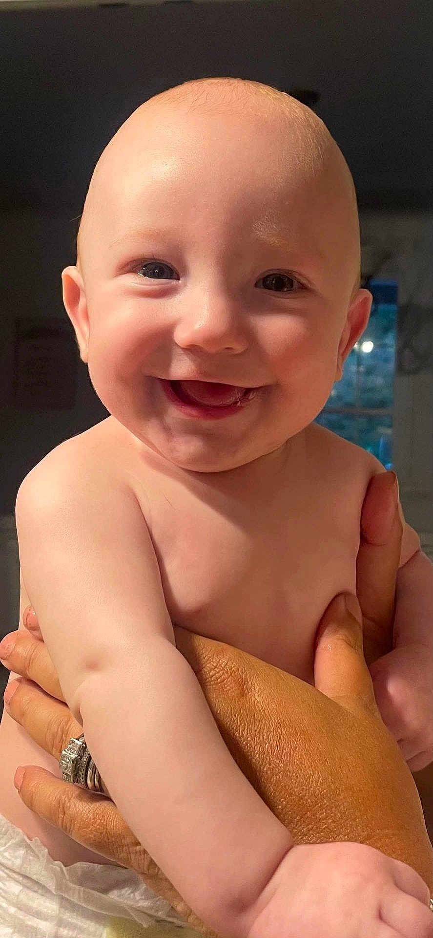 Ryland is registered to the contest to win money with this photo: baby, smiling, face, hands, skin, indoor, light, portrait, child, human, person, adult_hands, rings, happy, closeup, infant, cute, expression, holding, diaper
