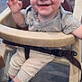 baby, high_chair, smile, child, happy, indoor, clothing, blanket, hand, face, person, footwear, sock, seat, belt, infant, cute, expression, cheerful, casual