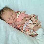 Sabrina Moon is registered to the contest to win money with this photo: baby, newborn, sleeping, infant, floral_dress, white_socks, soft_blanket, peaceful, cute, portrait, child, resting, indoors, cozy, small_hands, tiny_feet, fresh, adorable, calm, sleep