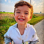 Eden a rejoint le concours — aidez-le/la à gagner de superbes lots ! boy, casual_clothing, child, cute, daylight, dirt_stain, field, flowers, greenery, happy, holding, nature, outdoor, playful, portrait, road, sky, smiling, sunlight, young_child