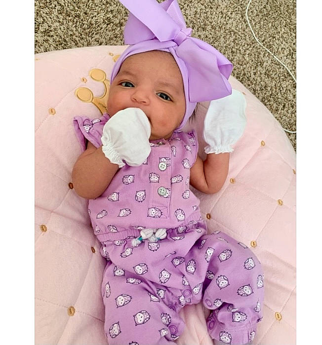 Alyssia is registered to the contest to win money with this photo: arm, baby, baby_sleeping, baby_toddler_clothing, cap, comfort, dress, face, hand, happy, head, headwear, magenta, person, pink, product, purple, skin, sleeve, textile