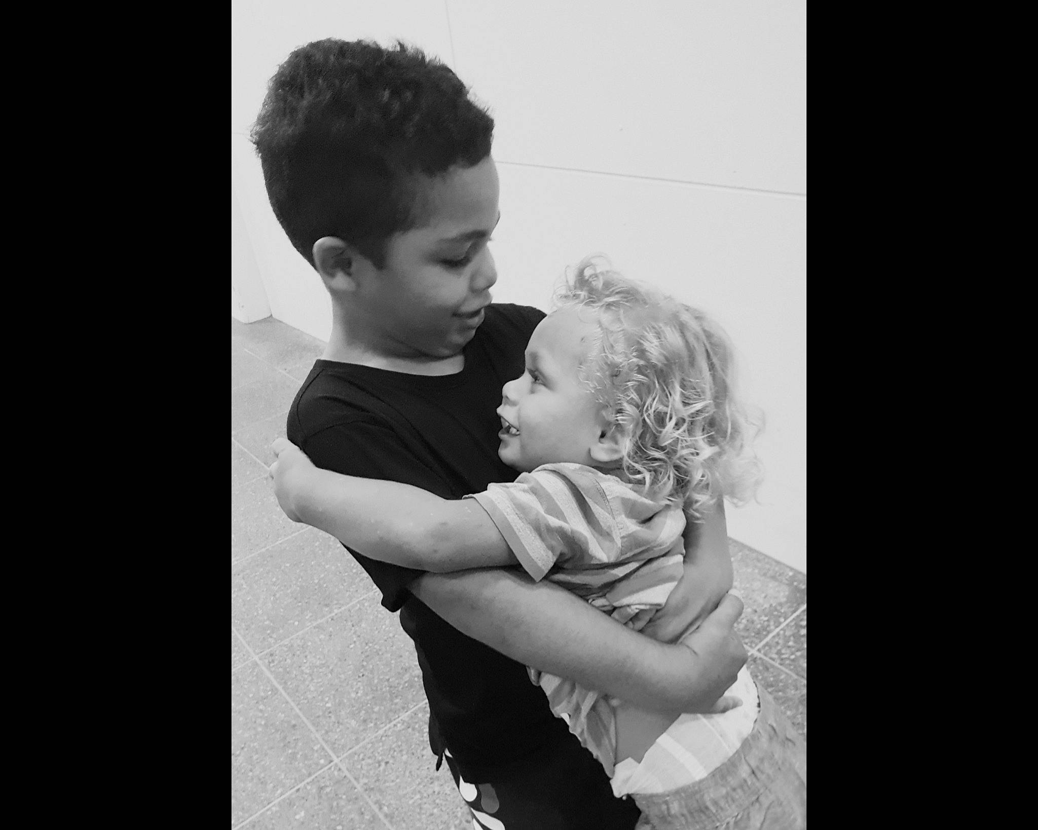 Trayzeke is registered to the contest to win money with this photo: arm, black, black_and_white, cheek, child, eye, hug, human, interaction, love, male, monochrome, monochrome_photography, people, person, photograph, photography, shoulder, snapshot, standing