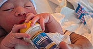 Francisco Gael joined the competition — help win amazing prizes! newborn, baby, infant, bottle, feeding, sleepy, hospital, hospital_bedding, striped_clothing, hat, adult_hand, portrait, closeup, indoors, cozy, blanket, bed, milk, formula, family