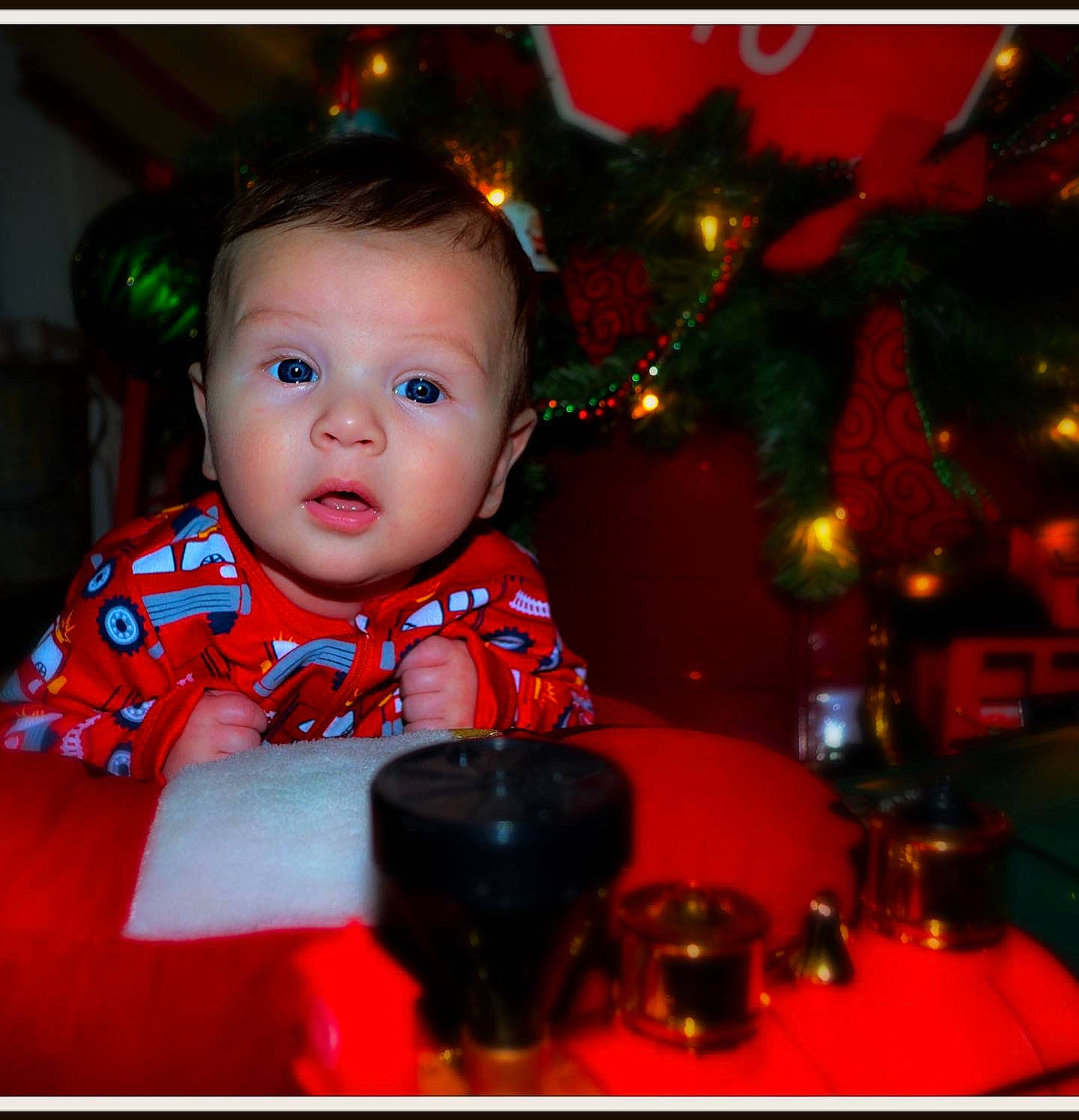 Colton is registered to the contest to win money with this photo: baby_toddler_clothing, child, christmas, christmas_decoration, christmas_eve, christmas_ornament, christmas_tree, event, flash_photography, fun, happy, head, holiday, interior_design, ornament, person, red, sitting, sleeve, surprise