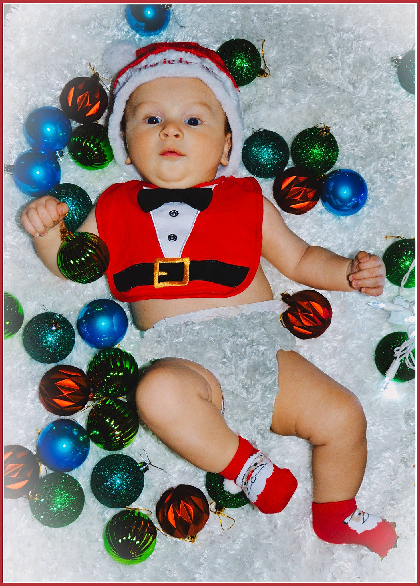 Colton is registered to the contest to win money with this photo: baby, baby_toddler_clothing, child, christmas, christmas_decoration, christmas_eve, christmas_ornament, event, fictional_character, font, fun, happy, headwear, holiday, holiday_ornament, ornament, person, play, sitting, sleeve