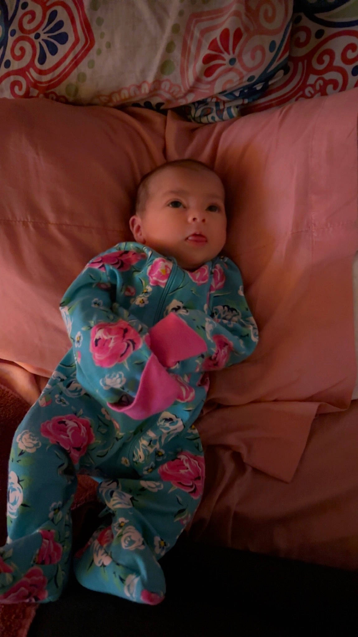 Stella is registered to the contest to win money with this photo: baby, baby_toddler_clothing, bed_sheet, bedding, bedtime, cheek, child, comfort, finger, linens, mouth, pattern, person, pink, room, sitting, skin, sleeve, textile, thigh