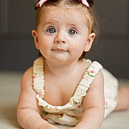 Hayden joined the competition — help win amazing prizes! baby, child, infant, toddler, girl, face, eyes, hair_bow, cute, portrait, skin, hands, clothing, romper, floor, indoor, expression, smile, curious, closeup