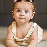 baby, child, infant, toddler, girl, face, eyes, hair_bow, cute, portrait, skin, hands, clothing, romper, floor, indoor, expression, smile, curious, closeup