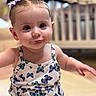 Hayden is registered to the contest to win money with this photo: baby, child, infant, girl, pigtails, bows, butterfly_pattern, clothing, portrait, indoor, crib, cute, expression, face, skin, sitting, smile, young, person, playful
