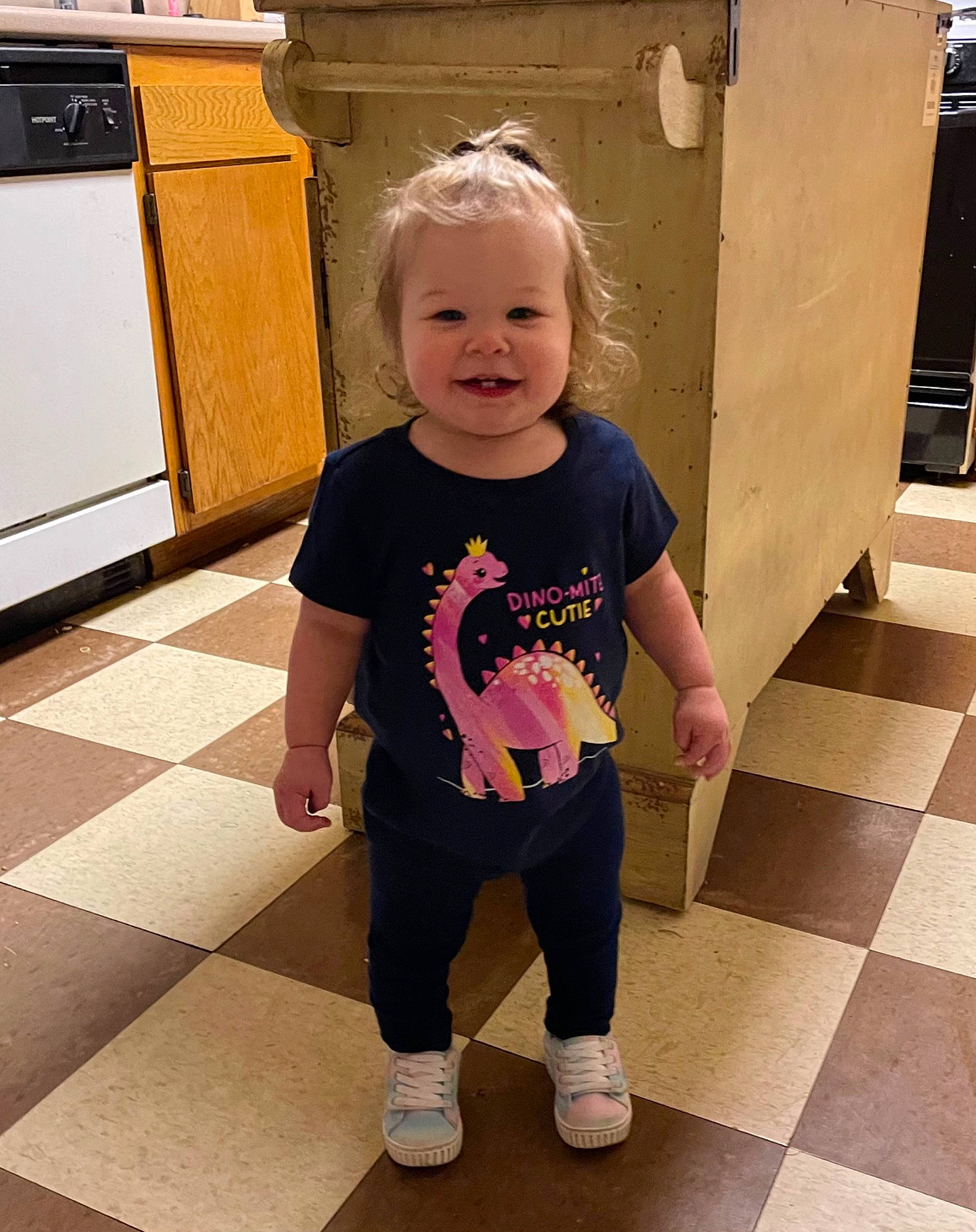 Aubree Mae is registered to the contest to win money with this photo: baby_toddler_clothing, cabinetry, face, floor, flooring, fun, hair, happy, head, joint, joy, knee, leg, person, shoulder, sleeve, smile, standing, t_shirt, toddler