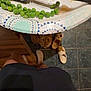 Pongo is registered to the contest to win money with this photo: plate, fork, peas, food, cat, orange_cat, slippers, floor, tile_floor, paper_plate, person, legs, socks, kitchen, curious_cat, green_vegetables, indoor, footwear, shadow, looking_up