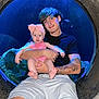 Rory is registered to the contest to win money with this photo: baby, child, young_adult, tattoo, aquarium, blue_light, circular_window, holding, pink_clothing, headband, bow, shorts, smile, person, portrait, indoor, fish_tank, legs, casual_clothing, happy