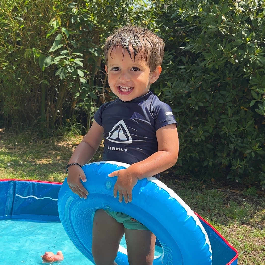 Ayden a rejoint le concours — aidez-le/la à gagner de superbes lots ! backyard, blue, child, fun, grass, greenery, happy, inflatable_ring, nature, outdoor, person, play, pool, smiling, summer, sunlight, swimwear, toy, water, wet_hair