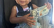 Zariah is registered to the contest to win money with this photo: baby, car_seat, cash, child, currency, dollar_bills, happy, indoor, infant, looking_at_camera, money, personal_finance, photograph, portrait, seatbelt, sitting, smiling, toddler, travel, vehicle