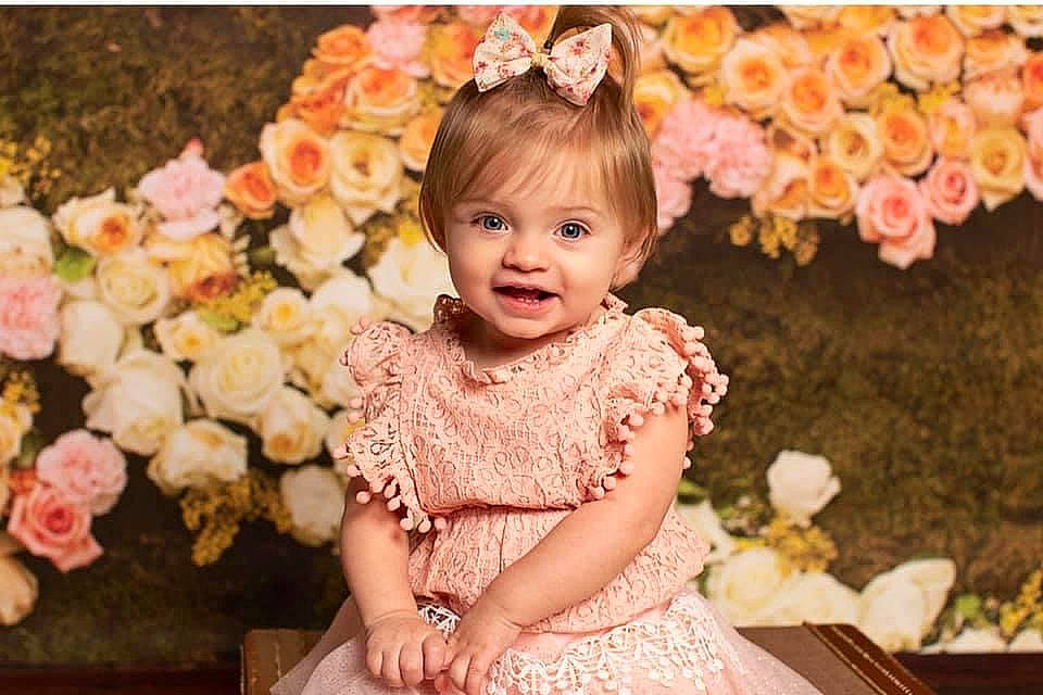 Emma Rose joined the competition — help win amazing prizes! baby_toddler_clothing, dress, embellishment, face, facial_expression, flash_photography, flower, flower_arranging, hairstyle, happy, head, human, iris, person, petal, pink, plant, smile, textile, toddler