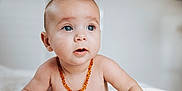 Gioia participe au concours pour gagner de l'argent avec cette photo : baby, infant, child, blue_eyes, amber_necklace, necklace, bare_torso, portrait, close_up, curious_expression, eyelashes, soft_light, indoor, cheeks, mouth_open, head, shoulder, bed_sheet, skin, one_person