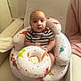 Liam is registered to the contest to win money with this photo: baby, infant, child, inflatable_chair, dinosaur_print, striped_shirt, indoor, cozy, blanket, cushion, seated, curious, wide_eyes, soft_lighting, home, furniture, footwear_free, cute, comfort, person