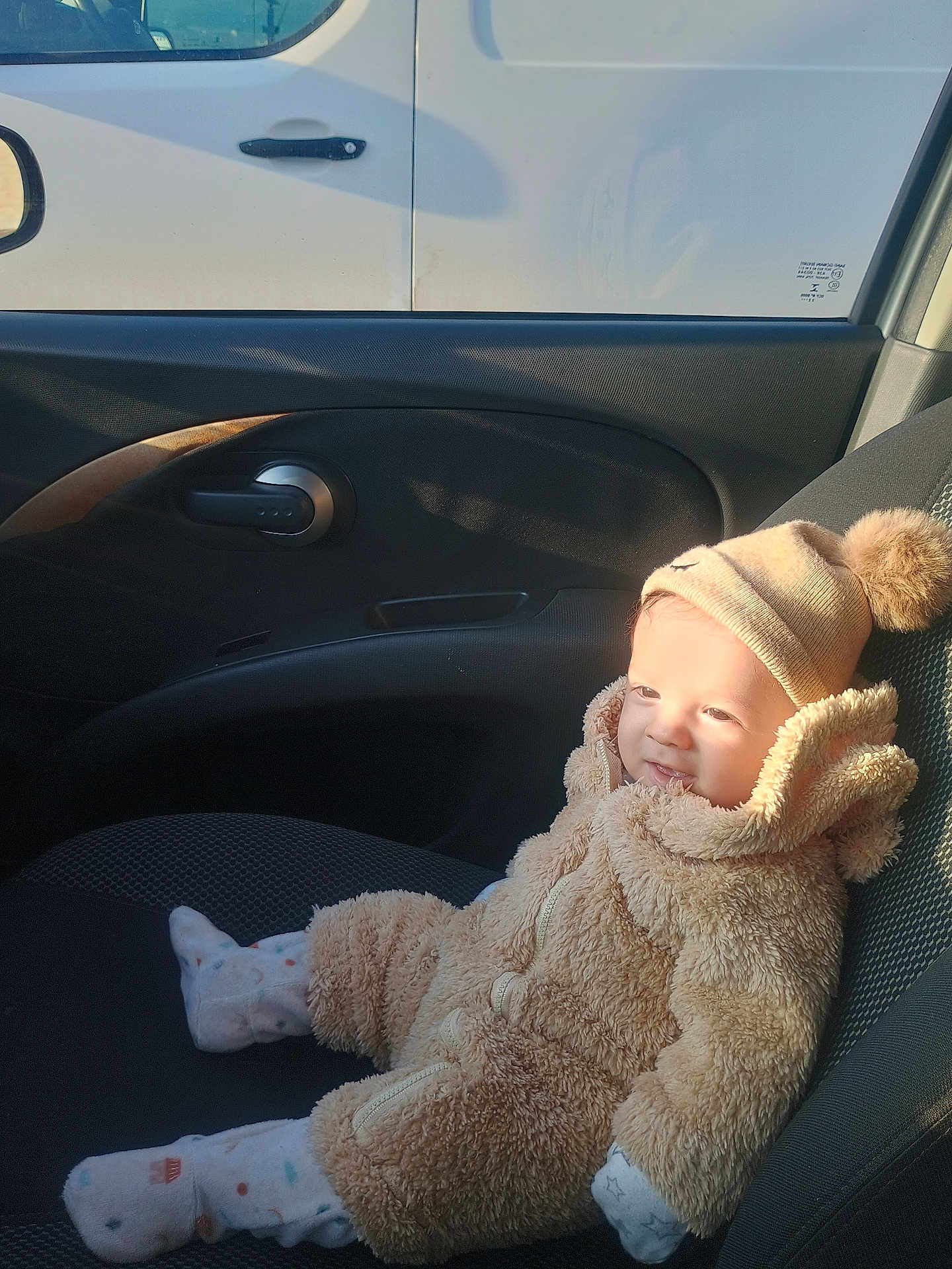 Sipan a rejoint le concours — aidez-le/la à gagner de superbes lots ! baby, child, car_interior, seat, clothing, hat, mittens, socks, cozy, warm, sunlight, cute, portrait, smile, infant, people, vehicle, window, car_door, seat_cover