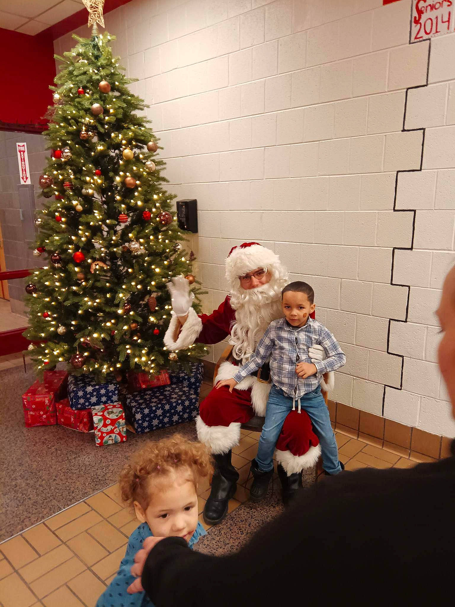 Torian Jr. joined the competition — help win amazing prizes! child, christmas_decoration, christmas_eve, christmas_ornament, christmas_tree, conifer, event, evergreen, fun, headwear, holiday, holiday_ornament, lap, ornament, person, plant, red, sitting, standing, toddler