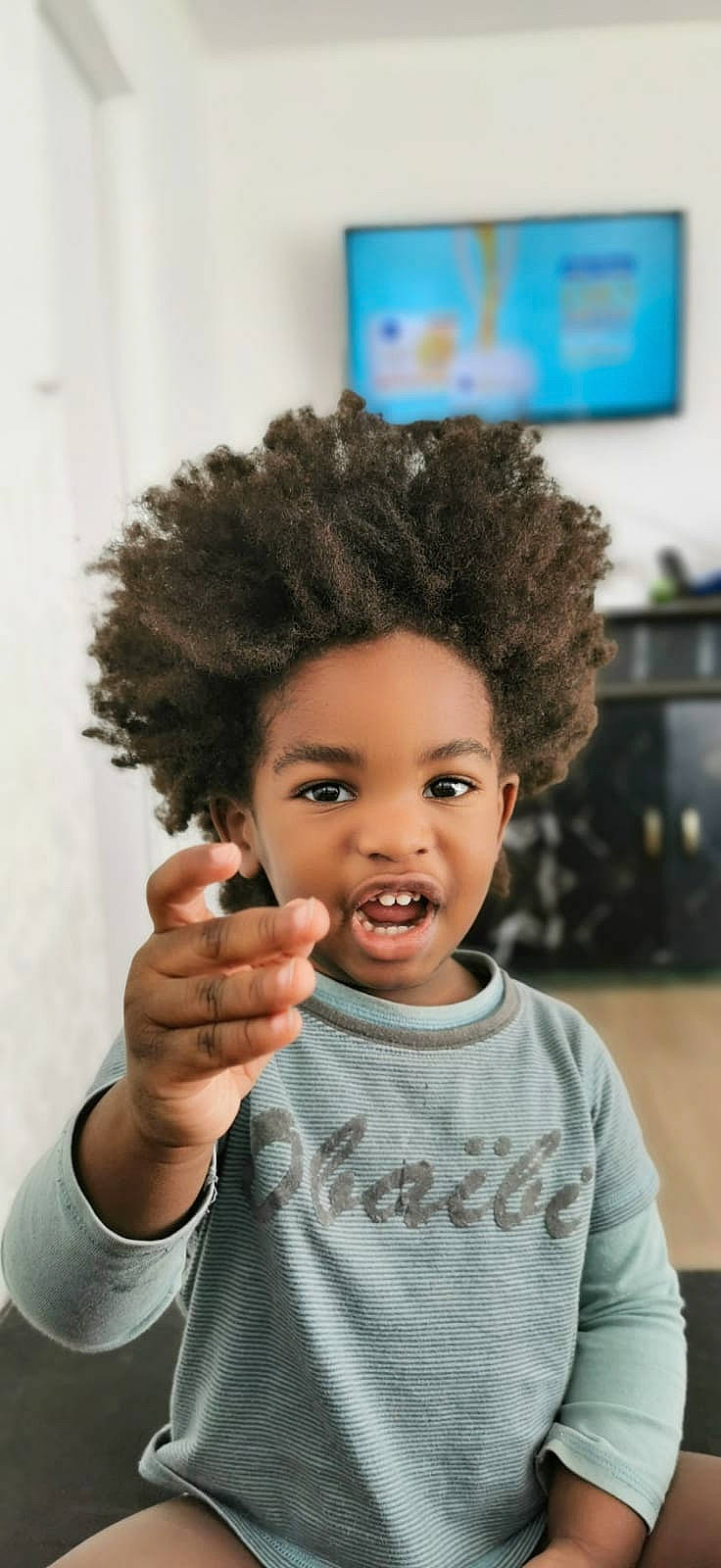 Celinïo a rejoint le concours — aidez-le/la à gagner de superbes lots ! afro, black_hair, cheek, chin, clothing, ear, eye, eyebrow, eyelash, face, fashion_design, gesture, hairstyle, happy, jheri_curl, lip, nose, person, skin, television