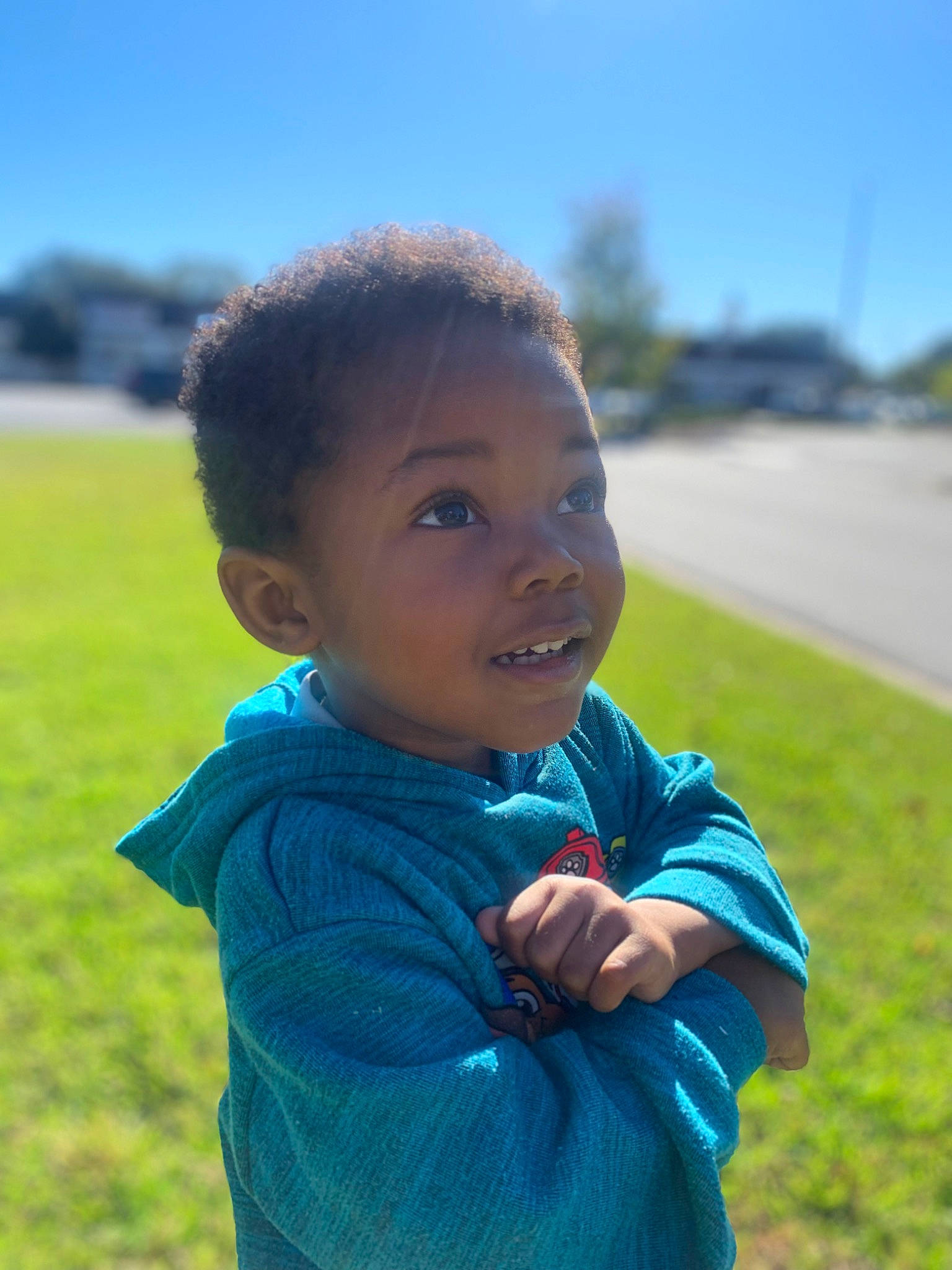 Fletcher is registered to the contest to win money with this photo: child, electric_blue, field, fun, gesture, grass, grassland, happy, landscape, leisure, meadow, people_in_nature, person, plant, prairie, recreation, sitting, sky, t_shirt, toddler
