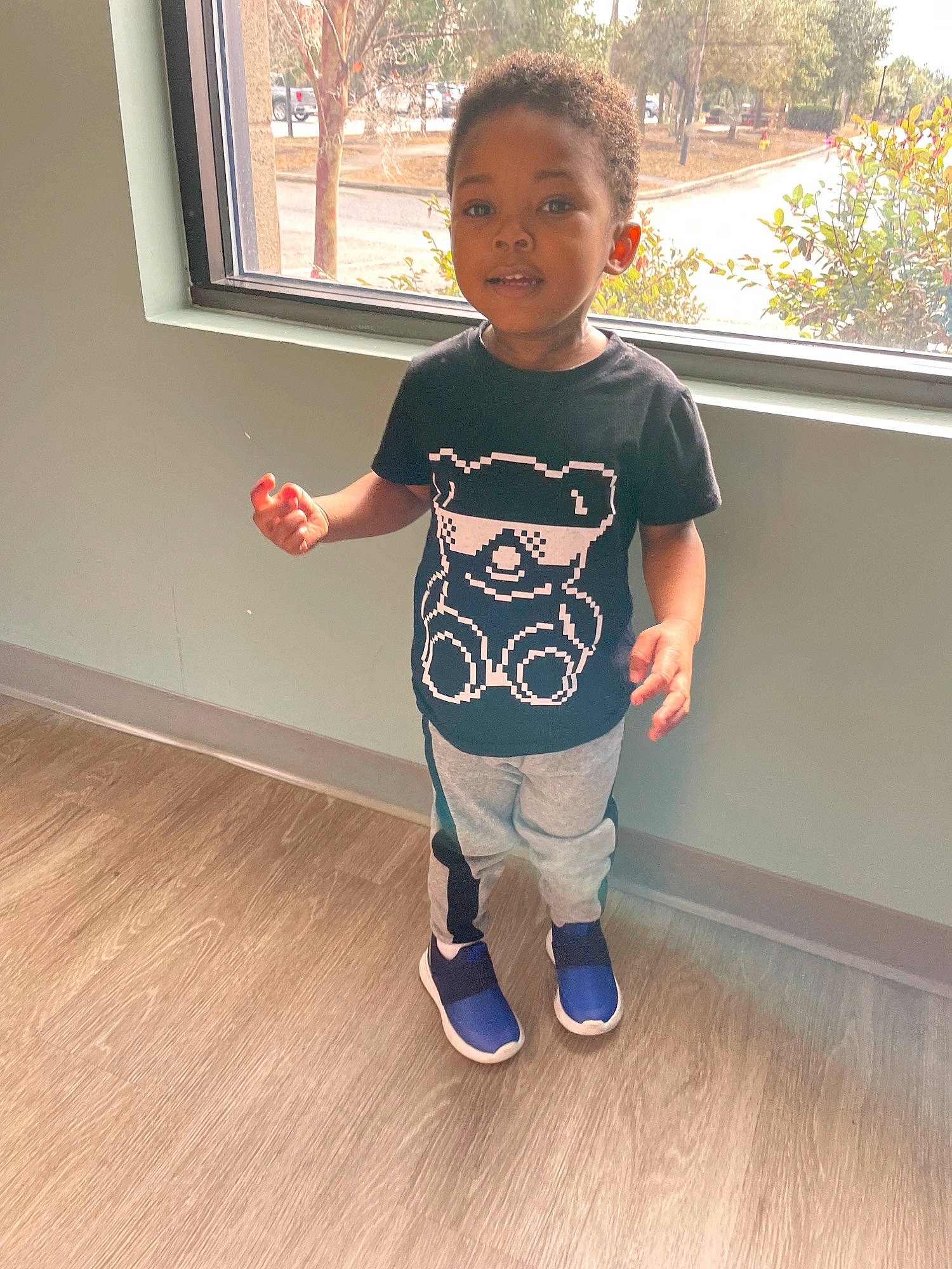 Fletcher joined the competition — help win amazing prizes! arm, baby_toddler_clothing, child, floor, flooring, happy, hardwood, head, laminate_flooring, leg, pattern, person, plant, sleeve, smile, standing, t_shirt, toddler, tree, window