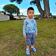 Steclariu a rejoint le concours — aidez-le/la à gagner de superbes lots ! child, boy, grass, tree, outdoor, dinosaur_sweater, blue_shoes, curious, greenery, nature, casual_clothing, daylight, park, young, portrait, standing, sky, clouds, building, serious_expression