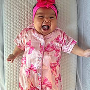 Brixlei joined the competition — help win amazing prizes! baby, infant, pink_outfit, headband, flower, smiling, laughing, cute, lying_down, cushion, textured_background, child, happy, one_person, indoors, soft_lighting, portrait, sleepsuit, newborn, playful