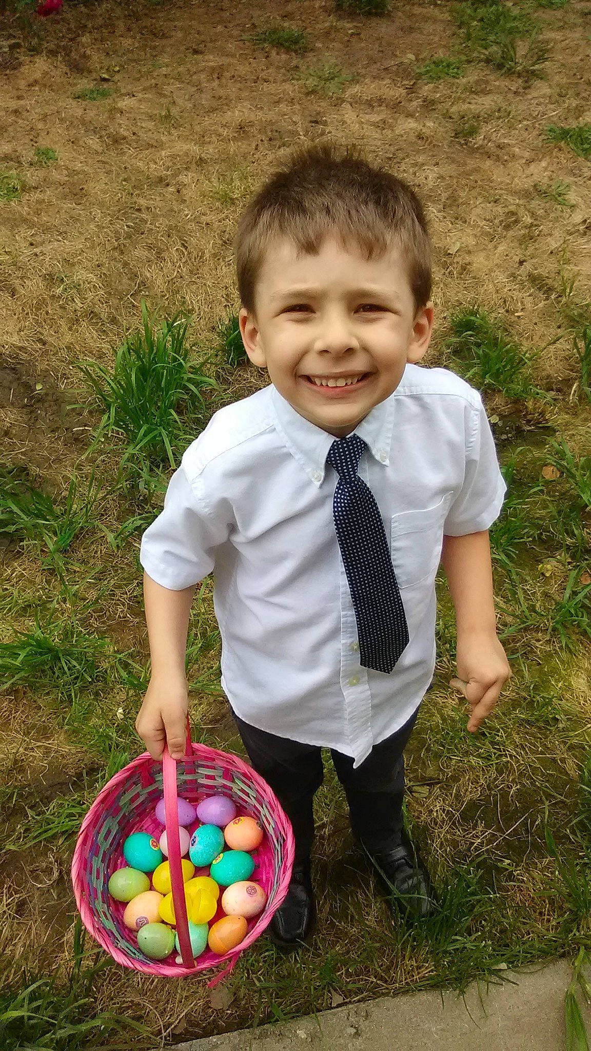 Austin is registered to the contest to win money with this photo: baby_toddler_clothing, ball, basket, child, easter, easter_egg, electric_blue, fun, grass, happy, joy, leisure, pattern, people_in_nature, person, plaid, smile, soil, spring, tie
