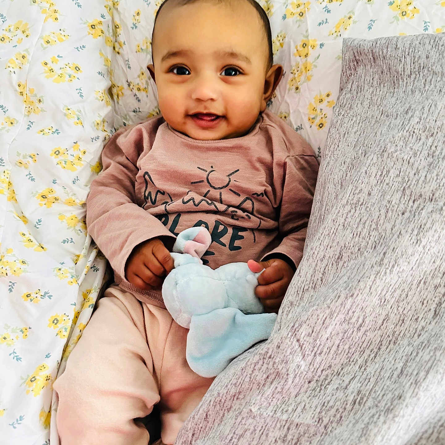 Madina is registered to the contest to win money with this photo: baby, blanket, child, cozy_clothing, cute, cute_baby, elephant, face, floral_pattern, hands, happy, indoor, infant, lying_down, pillow, pink_clothes, plush_toy, portrait, smiling, toy
