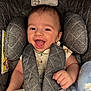 James is registered to the contest to win money with this photo: baby, smiling, car_seat, blanket, child, infant, happy, face, clothing, sitting, padded, cute, comfort, indoor, person, young_child, head, hand, expression, seatbelt
