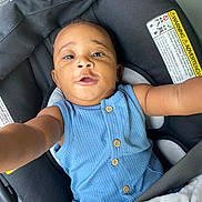 Angelo joined the competition — help win amazing prizes! baby, child, car_seat, seatbelt, blue_clothing, button_up, blanket, animal_print, infant, person, cute, portrait, indoor, sitting, reaching, young_child, car_interior, safety, smiling, face