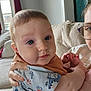 Kylan is registered to the contest to win money with this photo: baby, child, person, indoor, couch, hand, face, blue_eyes, clothing, glasses, window, curtain, adult, holding, portrait, expression, skin, short_hair, toddler, home