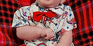 Kylan is registered to the contest to win money with this photo: baby, child, smiling, laughing, red_bow_tie, shirt, shorts, plaid_blanket, feet, happy, cute, indoor, sitting, infant, person, clothing, joyful, portrait, expression, casual